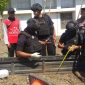 Petugas Jihandak Brimob Polda Jatim meminta warga menjauh dari TKP saat proses evakuasi mortir. (istimewa)
