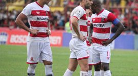 Greg Nwokolo, kapten Madura United, memimpin rekan-rekannya saat laga kontra PSM Makassar, di Stadion Andi Matalatta, Makassar, Minggu (31/06/2019). (foto: twitter madura united)