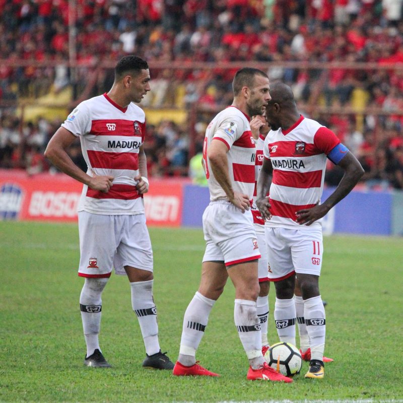 Greg Nwokolo, kapten Madura United, memimpin rekan-rekannya saat laga kontra PSM Makassar, di Stadion Andi Matalatta, Makassar, Minggu (31/06/2019). (foto: twitter madura united)