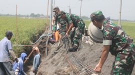 Anggota Kodim 0816 Sidoarjo sedang membangun plengsengan beton. (Fahmi/ SJ foto)