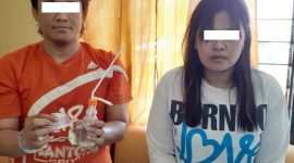 Kedua tersangka yang diamankan polisi menunjukkan barang bukti. (Didik/ SJ Foto)