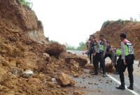 Polisi bergotong royong membersihkan material longsor di Jl Lingkar Utara, Desa Kebunan, Kota Sumenep, Jumat, 10/01/2020. (foto: istimewa)