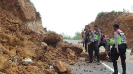 Polisi bergotong royong membersihkan material longsor di Jl Lingkar Utara, Desa Kebunan, Kota Sumenep, Jumat, 10/01/2020. (foto: istimewa)