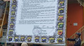 Warga membaca baliho raksasa yang dipasang petugas Polres Sumenep di Pasar Anom, Senin, 23/03/2020. (*/istimewa) 