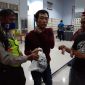 Seorang pria (berkaos merah) ditangkap saat akan memasok pil diduga narkoba ke Lapas Porong, Senin, 30/03/2020. (Yudha/SJ Foto) 