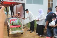 Achmad Fauzi didampingi Dewi Khalifah bagikan 1.100 bingkis sembako kepada tukang becak di Kota Sumenep, Minggu, 05/04/2020. (*/SJ Foto) 