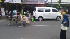 Dewi Sri, owner toko Dewi Sri berikan bungkus takjil kepada tukang becak yang melintas. (Mg1/SJ Foto)