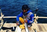 Seorang pemancing sedang mengumpulkan ikan yang berhasil ditangkap di atas pagan ikan. (Mg2/red)