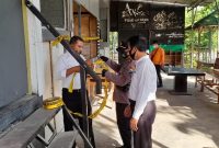Petugas memasang garis polisi di di cafe waroeng Apoeng Kheta yang berlokasi di Desa Saronggi, Kecamatan Saronggi. (Foto istimewa)