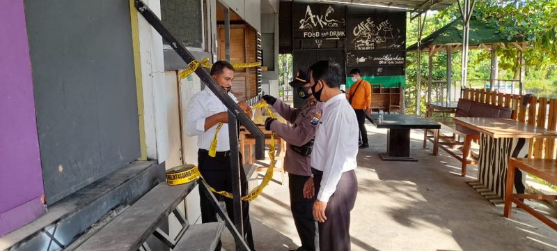 Petugas memasang garis polisi di di cafe waroeng Apoeng Kheta yang berlokasi di Desa Saronggi, Kecamatan Saronggi. (Foto istimewa)