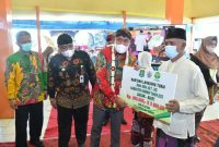 Foto:Bupati Sumenep, Achmad Fauzi, saat memberikan BLT DD kepada KPM didampingi camat lenteng dan pihak Bank BPRS sebagai penyalur