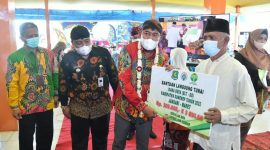 Foto:Bupati Sumenep, Achmad Fauzi, saat memberikan BLT DD kepada KPM didampingi camat lenteng dan pihak Bank BPRS sebagai penyalur