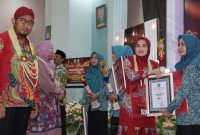 Foto: Bupati Sumenep didampingi istri tercinta menyerahkan hadiah kepada desa dalam rangka perlombaan desa dan kelurahan serta lomba 10 program pokok PKK