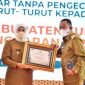 Foto:Bupati Fauzi saat menerima piagam penghargaan dari Gubernur Jatim