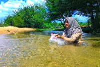 EKSOTIS: Pengunjung sedang menikmati kesegaran aliran sungai di Pantai Badur. (Foto istimewa)