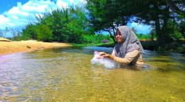 EKSOTIS: Pengunjung sedang menikmati kesegaran aliran sungai di Pantai Badur. (Foto istimewa)