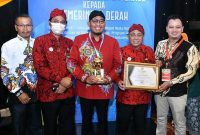 Foto:Cak Fauzi didampingi Kadinkes Sumenep saat menerima penghargaan bidang kesehatan. (Ist)