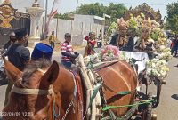 Foto:Kepala Desa Torbang bersama istri menaiki kereta kencana pada pawai Torbang Ritual Festival 2023