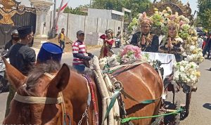 Kepala Desa Torbang bersama istri menaiki kereta kencana pada pawai Torbang Ritual Festival 2023