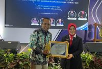 TERSENYUM : Ketua STKIP PGRI Sumenep, Asmoni saat menerima penghargaan di Malang