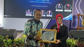 TERSENYUM : Ketua STKIP PGRI Sumenep, Asmoni saat menerima penghargaan di Malang