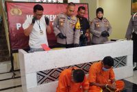 MENUNDUK: 2 pelaku pengeroyokan di Sumenep