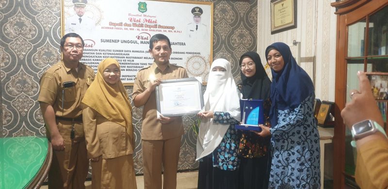 TERSENYUM: Kepala Dinas Sosial Sumenep, Mustangin, saat memberikan sertifikar kepada Direktur Paud El-Fath, Nurul Hayati (Sandi GT - Seputar Jatim)