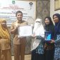 TERSENYUM: Kepala Dinas Sosial Sumenep, Mustangin, saat memberikan sertifikar kepada Direktur Paud El-Fath, Nurul Hayati (Sandi GT - Seputar Jatim)