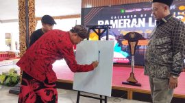 TAMPIL: Sekretaris Daerah (Sekda) Kabupaten Sumenep, Edy Rasyadi, saat melukis sebagai tanda membuka pameran lukisan (SandiGT - Seputar Jatim)