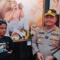 TERSENYUM : Kapolres Sumenep, AKBP Henri Noveri Santoso, saat membeli lukisan karya seniman penyandang disabilitas (SandiGT - Seputar Jatim)