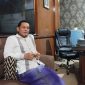 BERSARUNG : Kepala Dinsos Sumenep, Mustangin, saat ditemui wartawan seputarjatim.com di ruangan kerjanya (SandiGT - Seputar Jatim)
