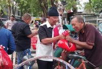 BAHAGIA : Ketua Banggar DPR RI, Said Abdullah memakai topi kupluk saat membagikan sembako kepada abang becak (SandiGT - Seputar Jatim)
