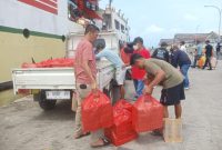 MEMBAWA: Ratusan nasi kotak dari Bupati Sumenep Achmad Fauzi Wongsojudo, untuk diberikan kepada para pemudik asal Pulau Masalembu di Pelabuhan Kalianget (Doc. Seputar Jatim)