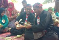 MERANGKAI: Bupati Sumenep, Achmad Fauzi Wongsojudo, didampingi warga membuat ketupat di Pantai Slopeng (SandiGT - Seputar Jatim)