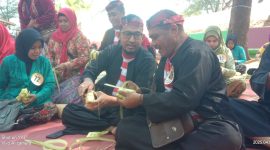 MERANGKAI: Bupati Sumenep, Achmad Fauzi Wongsojudo, didampingi warga membuat ketupat di Pantai Slopeng (SandiGT - Seputar Jatim)