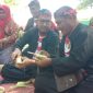 MERANGKAI: Bupati Sumenep, Achmad Fauzi Wongsojudo, didampingi warga membuat ketupat di Pantai Slopeng (SandiGT - Seputar Jatim)