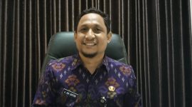 TERSENYUM: Kepala Dinas Pendidikan Sumenep, Agus Dwi Saputra saat diwawancarai di ruang kerjanya (SandiGT - Seputar Jatim)