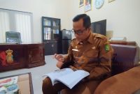 MEMBACA: Kepala BRIDA Sumenep, Benny Irawan saat memaparkan pokok permasalahan daerah di ruang kerjanya (SandiGT - Seputar Jatim)