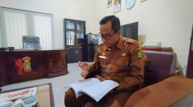 MEMBACA: Kepala BRIDA Sumenep, Benny Irawan saat memaparkan pokok permasalahan daerah di ruang kerjanya (SandiGT - Seputar Jatim)