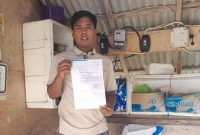 MEMPERLIHATKAN: Korban penipuan oknum petugas PLN, Jailani saat mendapatkan surat dari PLN Sumenep (SandiGT - Seputar Jatim)