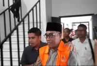 DIDAMPINGI: Kasi Intel Kejari Sumenep, Moch. Indra Subrata, saat membawa Kades Kangayan, Arsan, untuk dilakukan penahanan atas kasus dugaan pemalsuan ijazah (Mufti Che - Seputar Jatim)