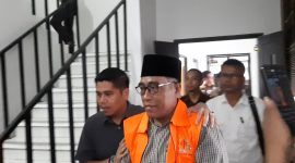 DIDAMPINGI: Kasi Intel Kejari Sumenep, Moch. Indra Subrata, saat membawa Kades Kangayan, Arsan, untuk dilakukan penahanan atas kasus dugaan pemalsuan ijazah (Mufti Che - Seputar Jatim)