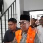 DIDAMPINGI: Kasi Intel Kejari Sumenep, Moch. Indra Subrata, saat membawa Kades Kangayan, Arsan, untuk dilakukan penahanan atas kasus dugaan pemalsuan ijazah (Mufti Che - Seputar Jatim)