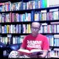 MEMBACA: Budayawan Sumenep, Ibnu Hajar, saat berada di antara tumpukan buku di perpustakaan pribadinya di rumahnya (Doc. Seputar Jatim)