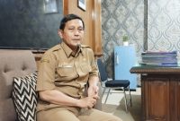 SANTAI: Kepala Dinsos Sumenep, Mustangin, saat menyampaikan terkait DTSEN di kantornya (SandiGT - Seputar Jatim)