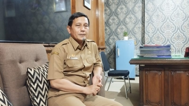 SANTAI: Kepala Dinsos Sumenep, Mustangin, saat menyampaikan terkait DTSEN di kantornya (SandiGT - Seputar Jatim)