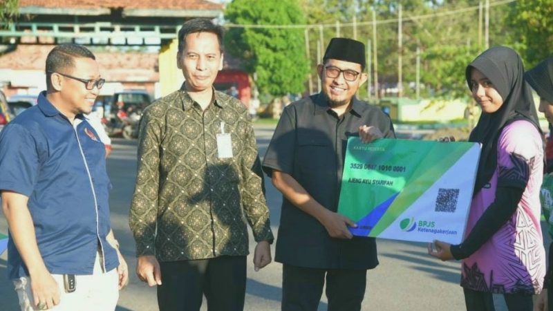 BAHAGIA: Bupati Sumenep, Achmad Fauzi Wongsojudo saat menyerahkan Kartu BPJS Ketenagakerjaan secara Simbolis kepada para Atlet Porprov 2025 (Doc. Seputar Jatim)