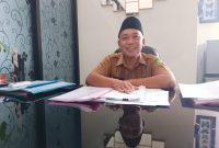 TERSENYUM: Kepala Bidang Penempatan dan Perluasan Kerja Disnaker Sumenep, Eko Kurniawan, saat diwawancarai di ruangannya (SandiGT - Seputar Jatim)