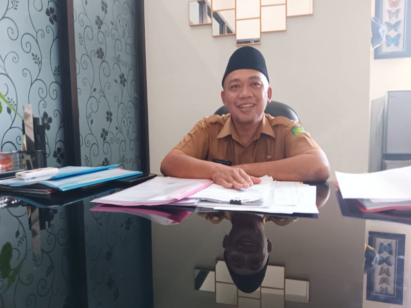 TERSENYUM: Kepala Bidang Penempatan dan Perluasan Kerja Disnaker Sumenep, Eko Kurniawan, saat diwawancarai di ruangannya (SandiGT - Seputar Jatim)