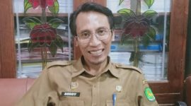 TERSENYUM: Kepala Bidang Persampahan DLH Sumenep, Deddy Surya, ketika berbicara tumpukan sampah di Sumenep (Doc. Seputar Jatim)